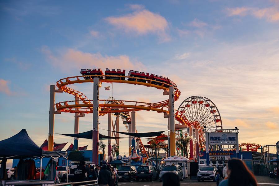 Pacific Park roller coaster and Ferris wheel at sunset, Santa Monica Pier, California