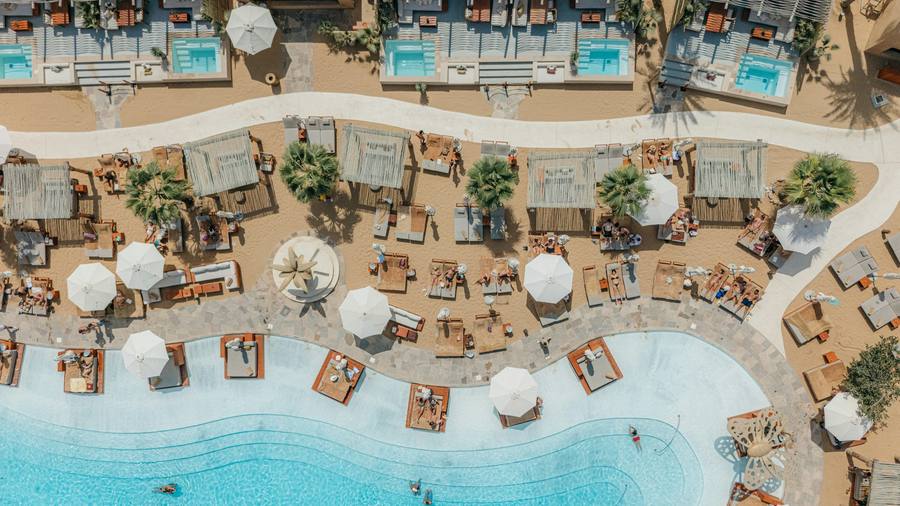 Aerial view of a luxury beach resort with pools and loungers
